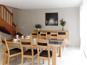 uma sala de jantar com uma mesa de madeira e cadeiras em Holiday Home Les Camélias - PGC106 by Interhome em Perros-Guirec