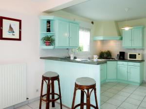 Trégastel-PlageにあるHoliday Home Palacret - TGP306 by Interhomeのキッチン(青いキャビネット、バースツール2つ付)