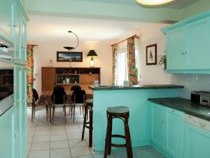 une cuisine avec des placards bleus et des tabourets de bar dans l'établissement Holiday Home Palacret - TGP306 by Interhome, à Trégastel-Plage