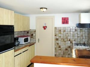 een keuken met een deur naar een keuken met een magnetron bij Holiday Home Les Tourteaux - TSM200 by Interhome in La Tranche-sur-Mer