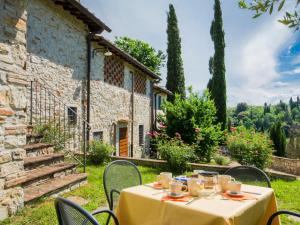 a table with chairs in front of a building at Apartment Il Mandorlato by Interhome in Grassina