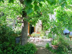 un jardin avec une table, des chaises et un arbre dans l'établissement Holiday Home Au Soleil Joyeux - CTU201 by Interhome, à Chissay-en-Touraine