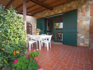 patio ze stołem i krzesłami na domu w obiekcie Holiday Home Coast-2 by Interhome w mieście Bibbona