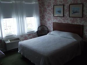 a bedroom with a bed and a window at Atlantic Hotel, Inc in Ocean City