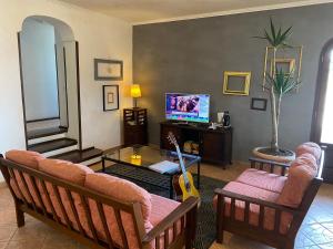 een woonkamer met een bank, een tafel en een tv bij Villa Monica B&B in Sorrento