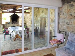 a room with a glass door with a table and a stone wall at Holiday Home Malbosc by Interhome in Saint-Genest-de-Bauzon