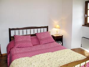 a bedroom with a bed with pink sheets and pillows at Holiday Home Malbosc by Interhome in Saint-Genest-de-Bauzon +10 photos