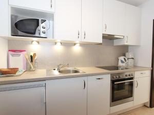 a kitchen with white cabinets and a sink and a microwave at Apartment Liebl-4 by Interhome in Seefeld in Tirol