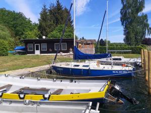 dos barcos están atracados en un muelle en el agua en Chalet Güstrower Chaussee by Interhome en Krakow am See