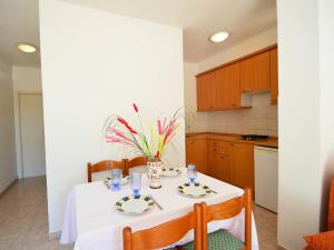 uma cozinha com uma mesa com uma toalha de mesa branca em Holiday Home Valentina em Jadrija