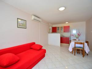 uma sala de estar com um sofá vermelho e uma cozinha em Holiday Home Valentina em Jadrija