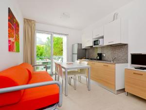 uma cozinha e sala de estar com mesa e cadeiras em Apartment Fiore-2 by Interhome em Lignano Sabbiadoro