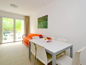 uma sala de estar com uma mesa e cadeiras e um sofá em Apartment Fiore-2 by Interhome em Lignano Sabbiadoro