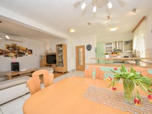 Una cocina y una sala de estar con mesa y sillas. en Holiday Home Bila Vila by Interhome, en Zadar