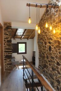 a stone wall in a living room with a staircase at A Nosa Casa in Belesar