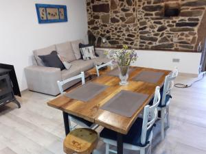 a wooden table and chairs in a living room at A Nosa Casa in Belesar