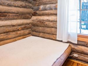 uma cama num quarto com uma parede de madeira em Holiday Home Retkietappi honkapirtti by Interhome em Juuma