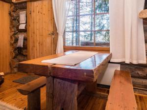 a wooden table in a room with a window at Holiday Home Retkietappi honkapirtti by Interhome in Juuma