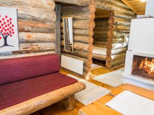 a room with a fireplace in a log cabin at Holiday Home Retkietappi honkapirtti by Interhome in Juuma