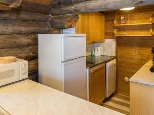 a white refrigerator in a kitchen with wooden walls at Holiday Home Retkietappi kelopirtti by Interhome in Juuma