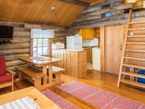 a kitchen with a table and a ladder in a cabin at Holiday Home Retkietappi kelopirtti by Interhome in Juuma