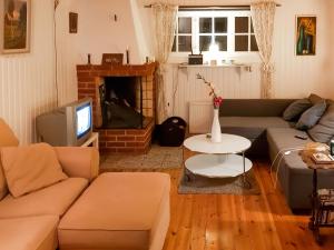 - un salon avec un canapé et une télévision dans l'établissement Chalet Höje - VMD220 by Interhome, à Hagfors