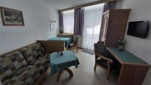 - un salon avec un canapé et une table dans l'établissement Ferienwohnungen am Lärchenweg, à Sesto