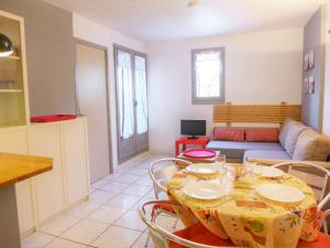 Una sala de estar con una mesa y sillas y un sofá. en Apartment Les Terrasses de la Méditerranée-2 by Interhome, en Saint Pierre La Mer