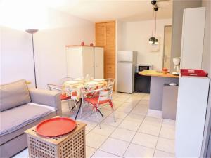 Una sala de estar con una mesa y una cocina. en Apartment Les Terrasses de la Méditerranée-2 by Interhome, en Saint Pierre La Mer