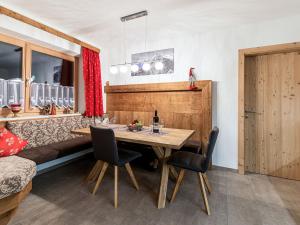 a dining room with a wooden table and chairs at Apartment Michi - MHO631 by Interhome in Schwendau