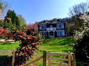 a house with a fence and a bush of roses at Holiday Home Arthog by Interhome in Arthog