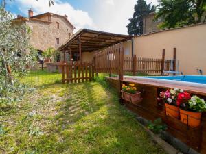 a backyard with a pool and a fence and flowers at Holiday Home Il Borgo di Gebbia by Interhome in Civitella in Val di Chiana