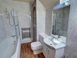 a bathroom with a sink and a toilet and a tub at Holiday Home South Street by Interhome in Dolgellau