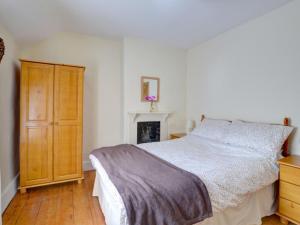 a bedroom with a bed and a wooden dresser at Holiday Home South Street by Interhome in Dolgellau