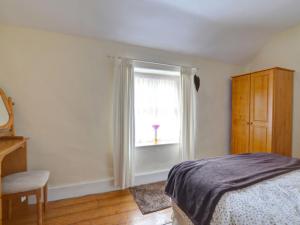 a bedroom with a bed and a window at Holiday Home South Street by Interhome in Dolgellau
