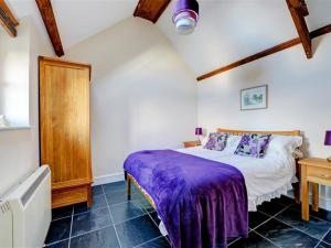 BegellyにあるHoliday Home Ivy by Interhomeのベッドルーム(紫の毛布付きのベッド1台付)