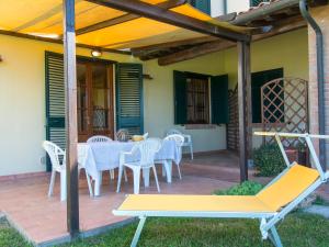 patio con tavolo, sedie e pergolato di Apartment Le Macine-3 by Interhome a Cecina