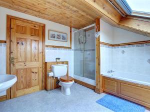 a bathroom with a toilet and a tub and a sink at Apartment Moelfre Apartment by Interhome in Moelfre