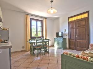 a living room with a table and chairs and a kitchen at Apartment Le Macine-2 by Interhome in Cecina