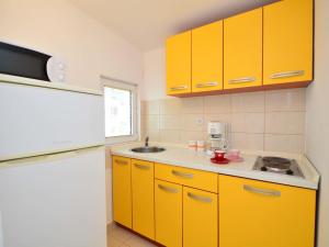 a kitchen with yellow cabinets and a sink at Apartment Lastavica-2 by Interhome in Jadrija