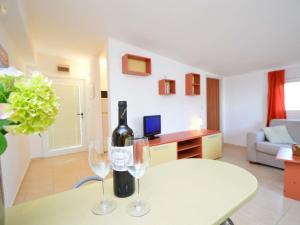 a bottle of wine and two wine glasses on a table at Apartment Lastavica-2 by Interhome in Jadrija