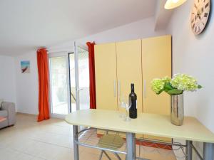 a kitchen with a table with a vase of flowers at Apartment Lastavica-2 by Interhome in Jadrija
