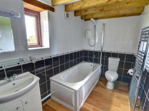 a bathroom with a tub and a toilet and a sink at Holiday Home Palmerston Primrose by Interhome in Haverfordwest