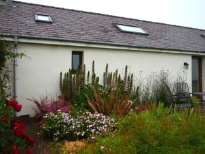 a garden in front of a house with flowers and plants at Holiday Home Palmerston Primrose by Interhome in Haverfordwest