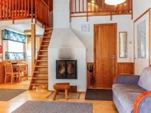 ein Wohnzimmer mit einer Treppe und einem Kamin in der Unterkunft Holiday Home Elma-maja by Interhome in Levi
