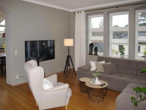Apartment Villa am Meer by Interhome في لوبمين: غرفة معيشة مع أريكة وكراسي وتلفزيون