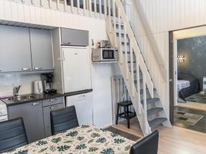 eine Küche und ein Esszimmer mit einer Treppe in einem winzigen Haus in der Unterkunft Holiday Home Lomakatti 7 b by Interhome in Vuokatti + 15 Fotos