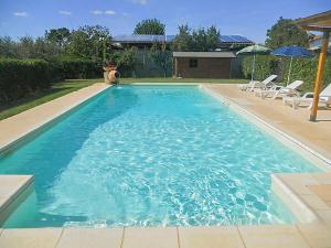 a large blue swimming pool with chairs and umbrellas at Holiday Home Lucia by Interhome in Cortona
