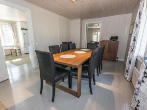 une salle à manger avec une table en bois et des chaises noires dans l'établissement Holiday Home Tallbacka by Interhome, à Bromary