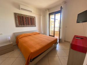 - une chambre avec un lit et une télévision dans l'établissement Trieste - Con servizio spiaggia - Narramondo Villas, à Giulianova